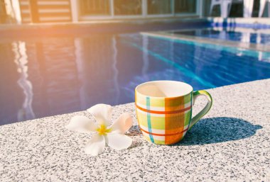 Renkli bardak kahve havuzu kenarında.
