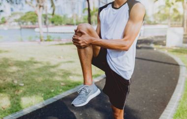 Genç adam organları, germe genel Park'ta jogging için Isınma.