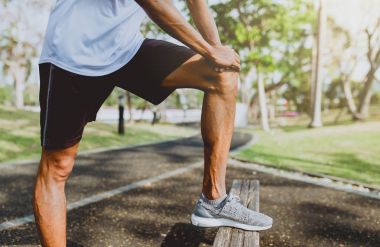 Genç adam organları, germe genel Park'ta jogging için Isınma.