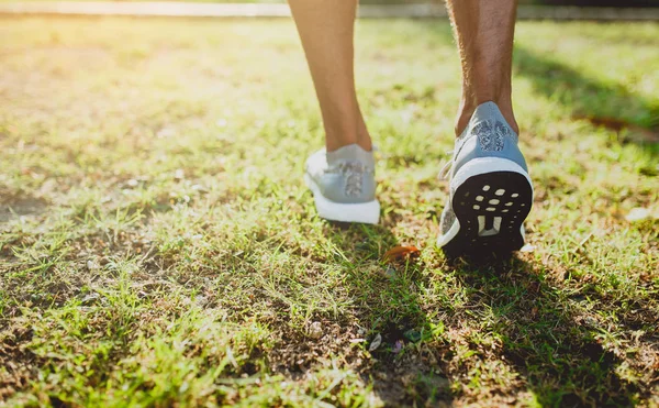 Feet of an athlete running on a park pathway training for fitness and healthy lifestyle. Royalty Free Stock Images