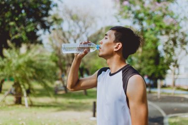 Yeşil ağaçlar arka plan üzerinde egzersiz sonra içme suyu spor dostum.