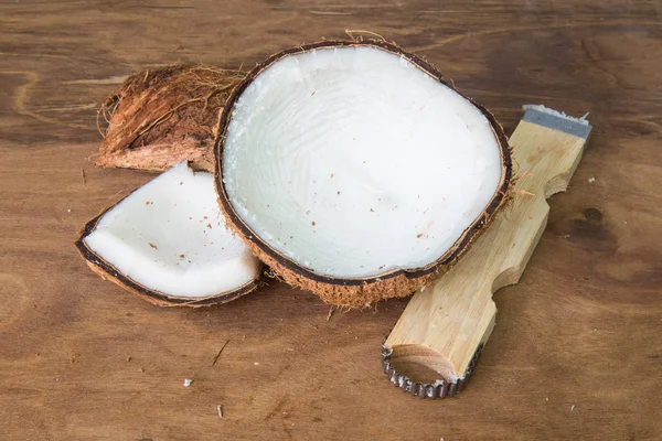 Ralador de coco e coco sobre fundo de madeira . — Fotografia de Stock