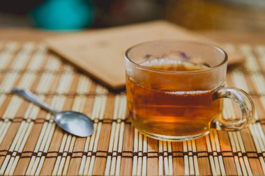 Cam bardak çay, çay kaşığı ahşap tablo.