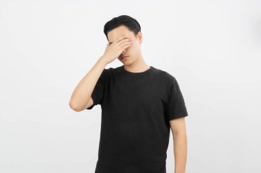 Asyalı genç adam mutsuz ve hayal kırıklığına uğramış. Beyaz arkaplanda negatif yüz ifadesi izole edildi.