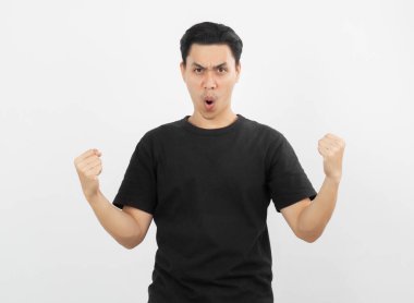 Mutlu yüzüyle yumruklarını kaldıran heyecanlı Asyalı genç adam beyaz arka planda izole edilmiş başarısını kutluyor..