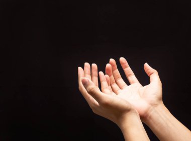 Karanlık arka planda dua eden eller, dine ve Tanrı 'ya olan inançla..
