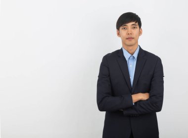 Yakışıklı Asyalı iş adamı beyaz arka planda kollarını kavuşturup kameraya bakıyor..