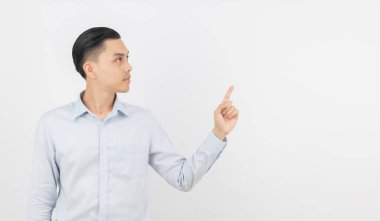 Mavi gömlekli genç Asyalı iş adamı beyaz arka planda izole edilmiş bir ürünü ya da fikri sunmak için elini kaldırıyor..