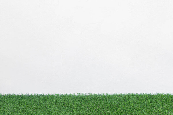 Зеленый травяной пол с белым бетонным фоном, макет для дизайна
.