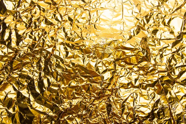 Gold crumpled foil paper texture background.