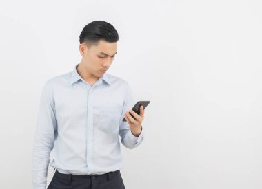 Genç Asyalı yakışıklı iş adamı akıllı telefon oynuyor ve beyaz arka planda izole edilmiş olarak düşünüyor..