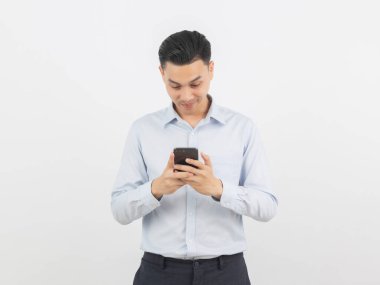 Genç Asyalı yakışıklı iş adamı beyaz arka planda sırıtarak akıllı telefon oynuyor..