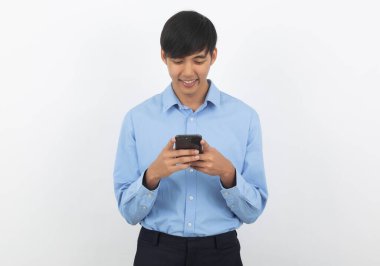 Genç Asyalı yakışıklı iş adamı beyaz arka planda sırıtarak akıllı telefon oynuyor..