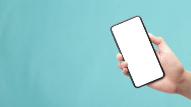 Mavi arkaplanda kırpma yolu ile izole edilmiş boş ekran ile siyah akıllı telefonu tutan erkek el.