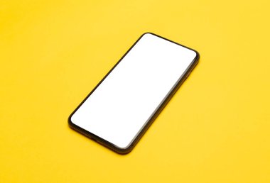 Sarı arkaplanda boş ekran maketi olan siyah akıllı telefon. Kesme yolu.