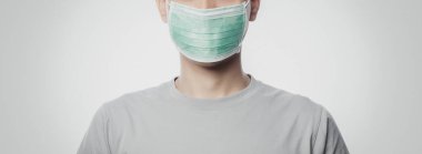 Enfeksiyonu önlemek için hijyenik maske takan genç adam, 2019-nCoV ya da koronavirüs. Öğleden sonra 2.5 gibi hava yoluyla bulaşan solunum hastalığı beyaz arka planda izole edilmiş. Sancak boyutu.