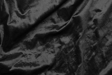 Soyut siyah kumaş kumaş dokusu arka plan veya sıvı dalga veya dalgalı kıvrımlar.