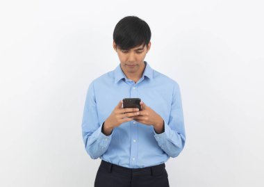 Genç Asyalı yakışıklı iş adamı beyaz arka planda sırıtarak akıllı telefon oynuyor..