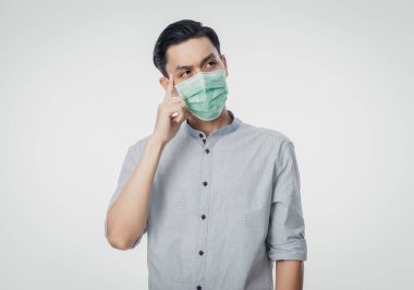 Genç Asyalı iş adamı hijyenik maske takıyor ve enfeksiyonu önlemeye çalışıyor, 2019-nCoV veya coronavirüs. Öğleden sonra 2.5 gibi hava yoluyla bulaşan solunum hastalığı beyaz arka planda izole edilmiş..