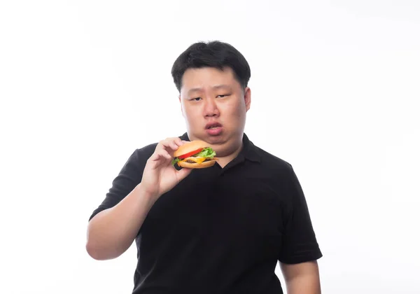 Junger Asiatischer Fetter Mann Schwarzem Poloshirt Isst Hamburger Mit Glücklichem — Stockfoto