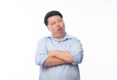 Mavi gömlekli Asyalı şişman adam kollarını kavuşturdu ve beyaz arka planda izole edilmiş kopyasal alan arıyor..