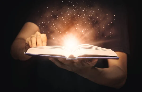 男は光と魔法の粉を成長させる魔法の本を開いた 学びと教育の概念 — ストック写真