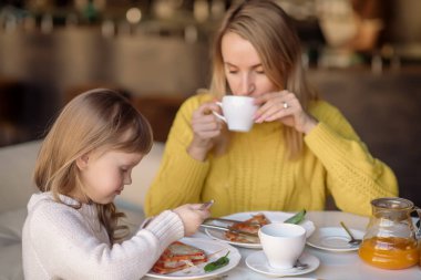 6 yaşında bir kız ve annesi bir kafede.