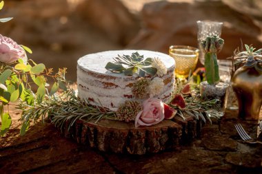 Kırsal tarzda, kremalı, incirli ve çiçek süslemeli açık pasta.