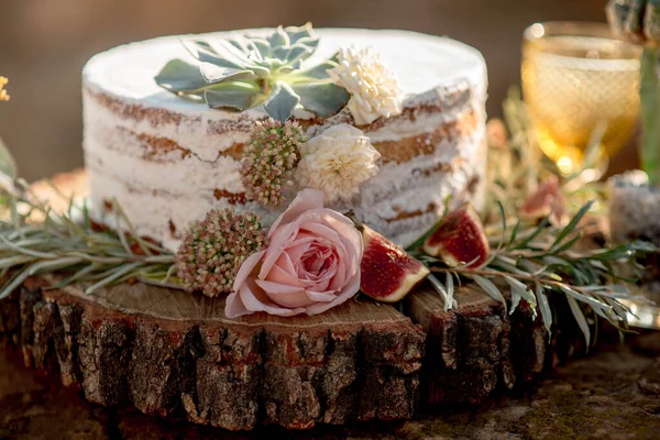 Kırsal tarzda, kremalı, incirli ve çiçek süslemeli açık pasta.