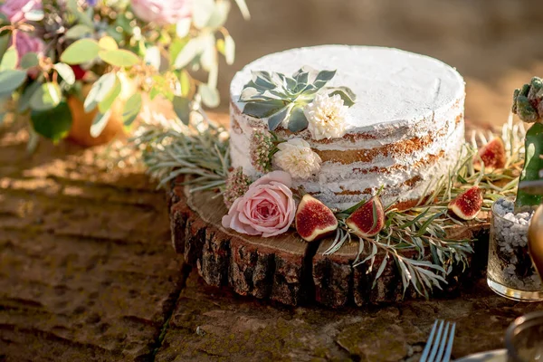 Kırsal tarzda, kremalı, incirli ve çiçek süslemeli açık pasta.