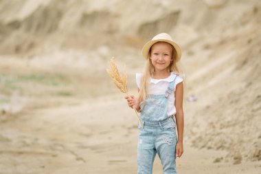 Kumsalda kot giyen 8 yaşında bir kız.