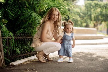 Küçük kız, annesiyle ilk adımlarını atıyor.