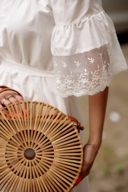 Bir kadının ellerinde İtalyan tarzı bir yaz çantası