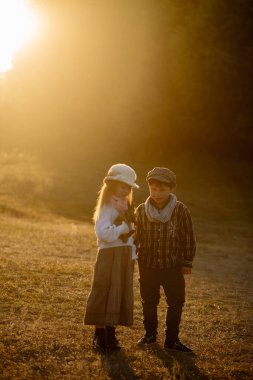Kız ve oğlan 8 yaşında, tavşanlarla yürüyüşe çıkmış.