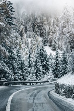 Güney Tyrol 'daki İtalyan Alpleri' nde yol kıvrımlı, kış / güneşli kış günlerinde sert gölgeler ve bol karla kaplı.