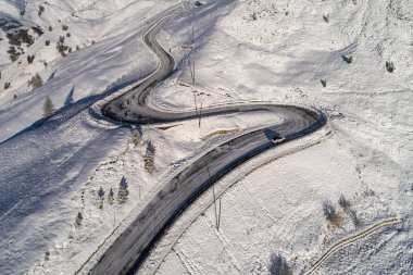Güney Tyrol 'daki İtalyan Alpleri' nde yol kıvrımlı, kış / güneşli kış günlerinde sert gölgeler ve bol karla kaplı.