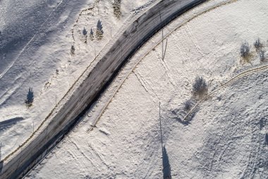 Güney Tyrol 'daki İtalyan Alpleri' nde yol kıvrımlı, kış / güneşli kış günlerinde sert gölgeler ve bol karla kaplı.