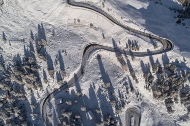 Güney Tyrol 'daki İtalyan Alpleri' nde yol kıvrımlı, kış / güneşli kış günlerinde sert gölgeler ve bol karla kaplı.