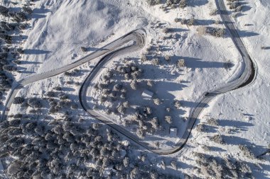 Güney Tyrol 'daki İtalyan Alpleri' nde yol kıvrımlı, kış / güneşli kış günlerinde sert gölgeler ve bol karla kaplı.