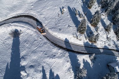 Güney Tyrol 'daki İtalyan Alplerinde yol kıvrımlı, kış boyunca kar temizleyicisi / güneşli kış günü sert gölgeler ve yoğun kar ile