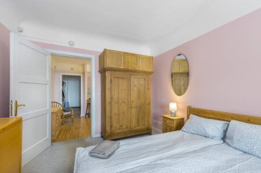 Büyük yatağı ve ahşap dolabı olan eski dairedeki yatak odası. 