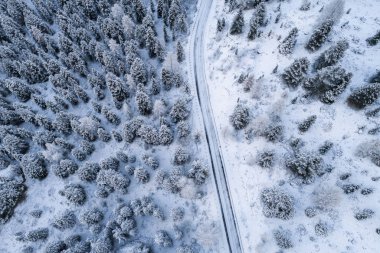 Güney Tyrol 'daki İtalyan Alpleri' nin karlı dağlarındaki kavisli yolun hava manzarası, kış / güneşli kış günlerinde sert gölgeler ve bol karla kaplı.