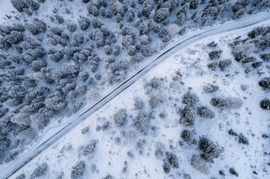 Güney Tyrol 'daki İtalyan Alpleri' nin karlı dağlarındaki kavisli yolun hava manzarası, kış / güneşli kış günlerinde sert gölgeler ve bol karla kaplı.