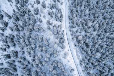 Güney Tyrol 'daki İtalyan Alpleri' nin karlı dağlarındaki kavisli yolun hava manzarası, kış / güneşli kış günlerinde sert gölgeler ve bol karla kaplı.