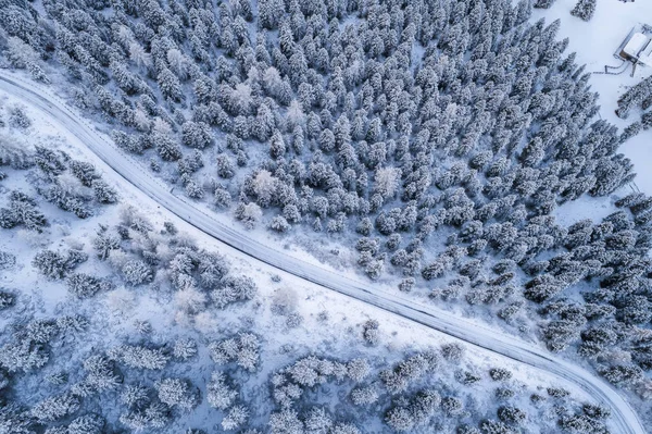 Güney Tyrol 'daki İtalyan Alpleri' nin karlı dağlarındaki kavisli yolun hava manzarası, kış / güneşli kış günlerinde sert gölgeler ve bol karla kaplı.