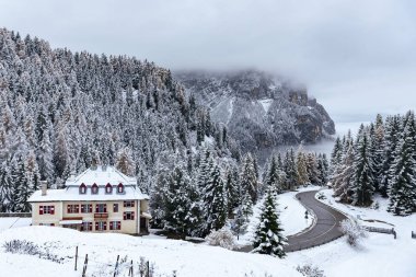 Güney Tyrol 'daki İtalyan Alplerindeki Dağ Oteli ve Virajlı Yol, kış / Foggy kış akşamı