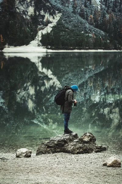傍晚时分 一位男性摄影师站在拉戈德布赖斯湖 Pragser Wildsee Braies湖 的小岩石顶上 在水中倒影 — 图库照片