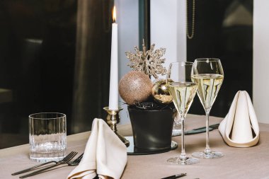 Lokantada bir mum ve iki şampanya bardağıyla bir masa. Akşamın geç saatlerinde, yüksek izo görüntü.