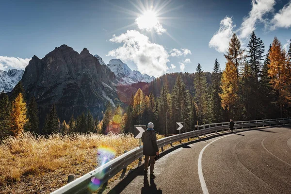 Arkadan çekilen genç erkek fotoğrafçı İtalyan Alplerinde dolomitlerin fotoğraflarını çekiyor / Güneşli bir günde arka planda Dolomite Dağları / High Iso