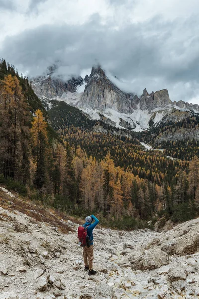 イタリアのアルプスやドロマイトの山々を背景にしたカラフルなジャケット姿の若い男性が 日没時 高イソのイメージ — ストック写真